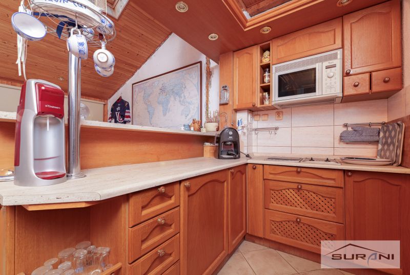 A kitchen in a family house with wooden decor, a map, and kitchen equipment.