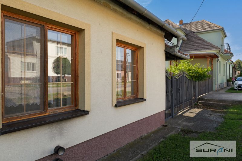 A family house on Hlavná Street in Štefanová with brown windows and a green lawn.