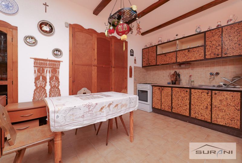 A kitchen in a family house with rustic decor and wall decorations above the table.