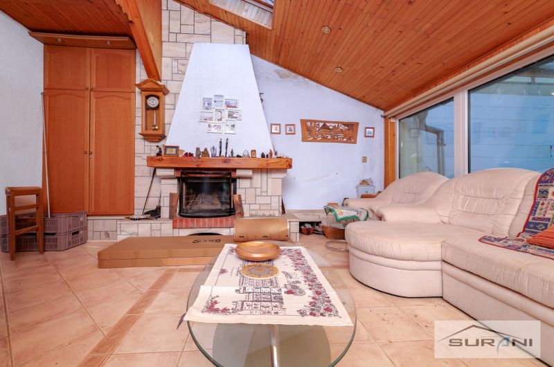 Living room with a fireplace and a sofa in a family house, floor with wooden decor.