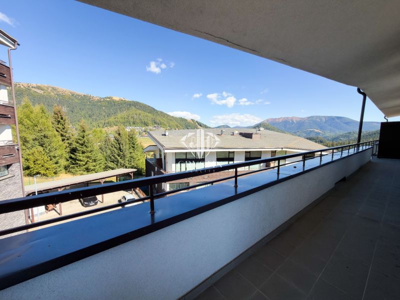 The balcony of the 3-room apartment in Donovaly offers a view of the mountains and rooftops.
