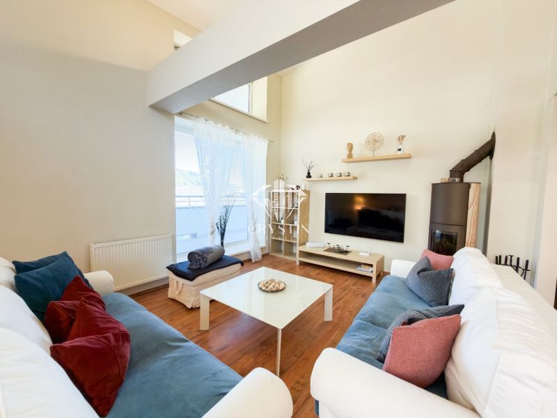 Living room in a three-room apartment with a wooden decor floor, comfortable couches, television.