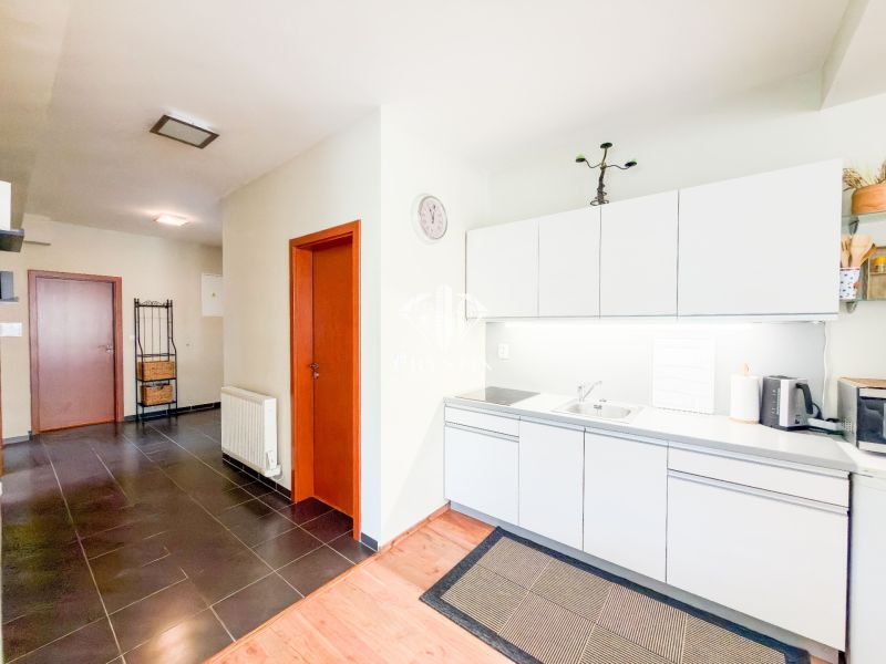 A kitchen in a 3-room apartment with white cabinets and a wood-patterned floor.