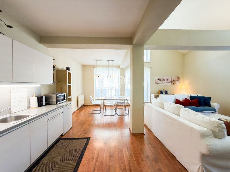 Kitchen and living room with wood-patterned flooring in a 3-room apartment.