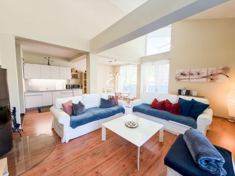 Living room in a 3-room apartment with a wooden decor floor and a light-colored sofa.