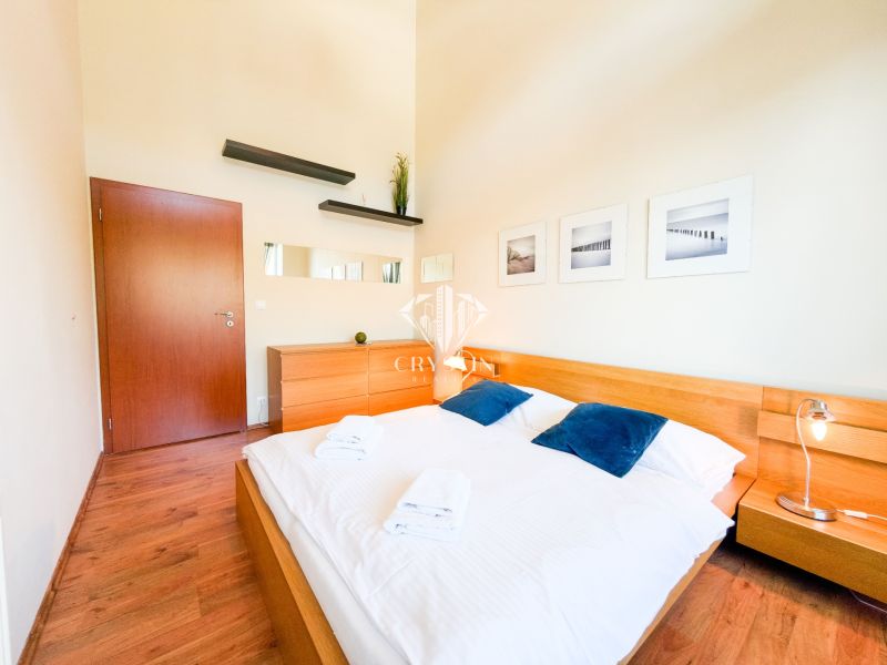 A bedroom with wood-patterned flooring, a bed, a dresser, and decorations in a 3-room apartment.