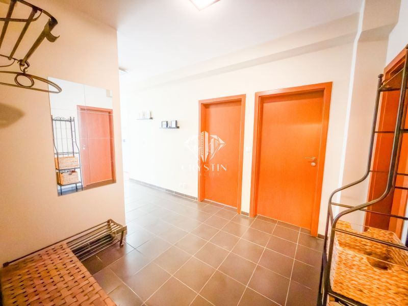 A hallway in a 3-room apartment with a mirror, black tiles, and wooden doors.