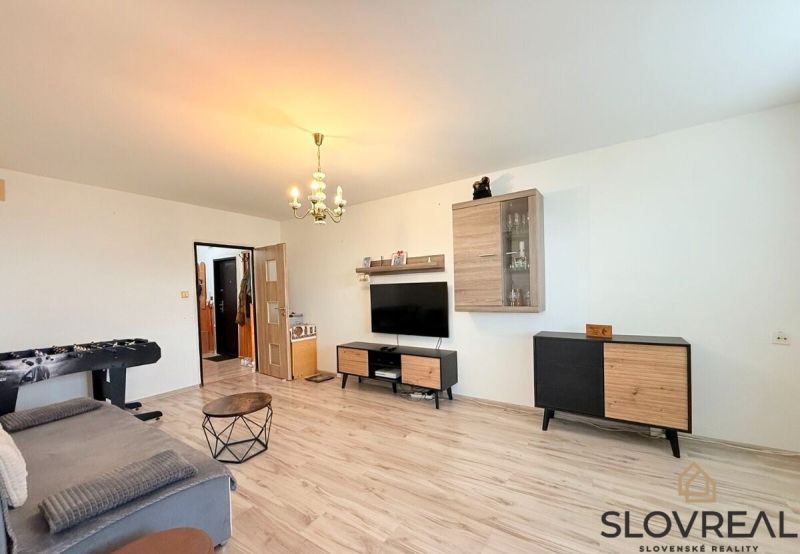 Living room in a 3-room apartment with a wooden decor floor and furniture.