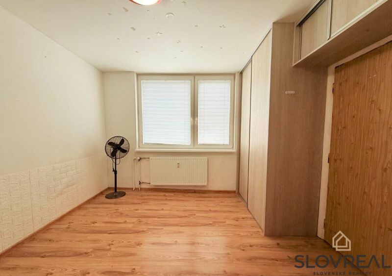 A room with a wooden floor decor, a fan, and storage space in a 3-room apartment.