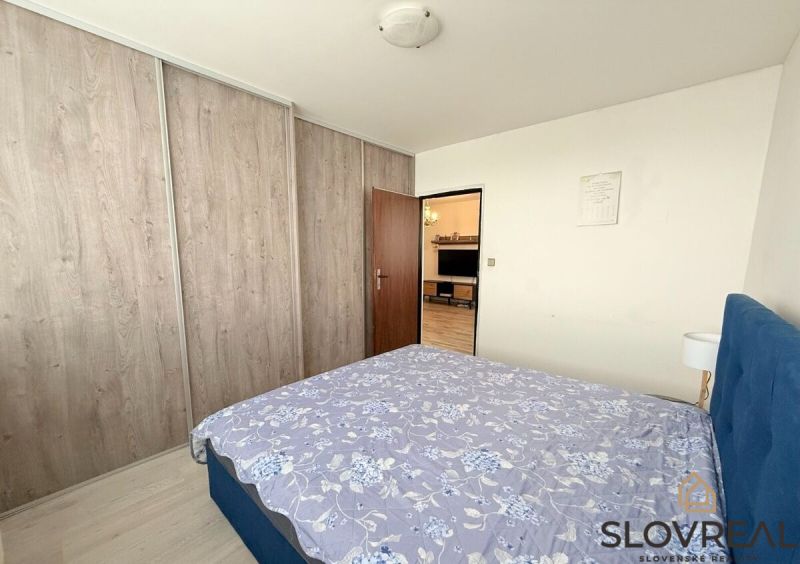 Bedroom with a bed, built-in wardrobe, and passage to the living room in a 3-room apartment.