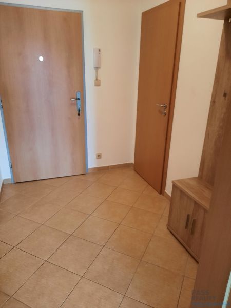 Entrance hallway in a 2-room apartment with tiles and wooden doors.