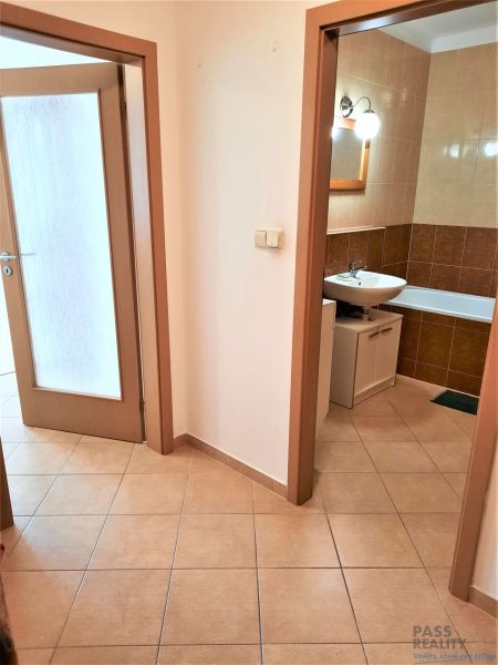 A hallway with tiles and a view of the bathroom in a 2-room apartment.