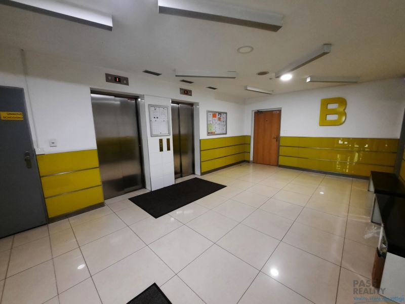 Interior with two elevators, yellow walls, and light tiles in a 2-room apartment.