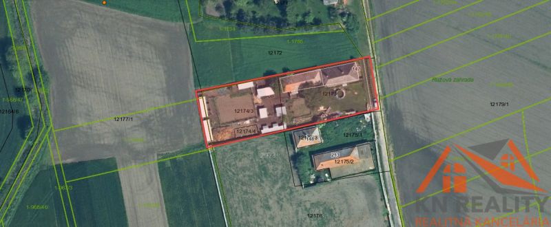 Aerial view of family houses in Komárno surrounded by fields and vegetation.
