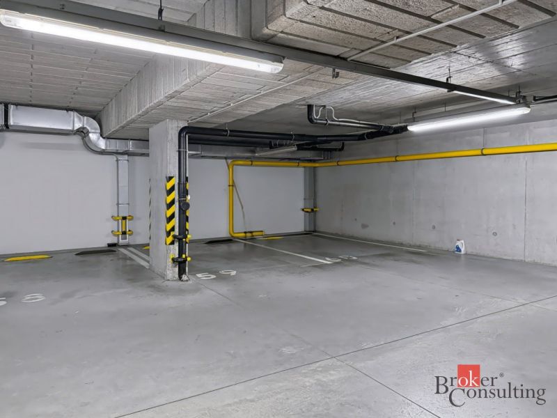 A parking space in an underground garage on a color-marked floor.
