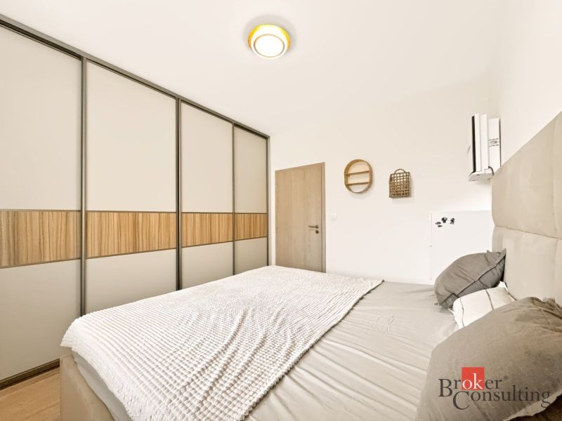 A bedroom with a large built-in wardrobe and a bed in a 2-room apartment.