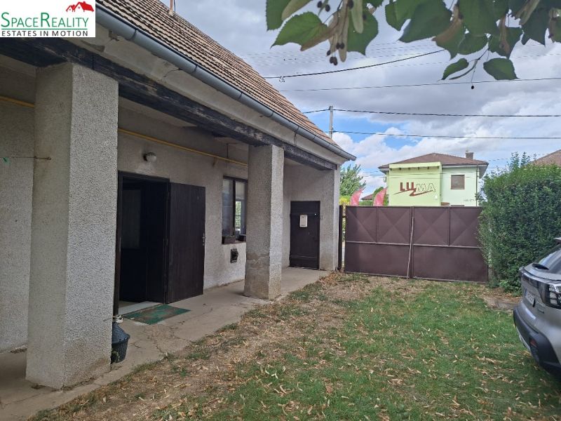 An older building with a garden on Main Street in Viničné, suitable for residential land.