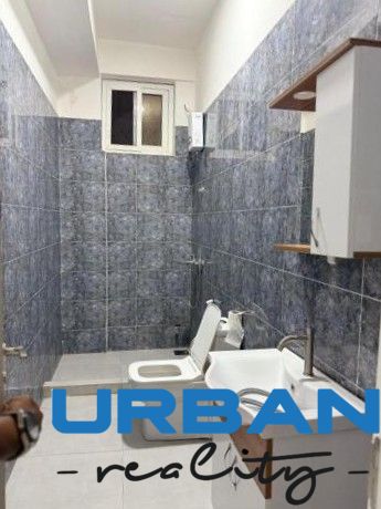 Bathroom in a 2-room apartment with ceramic tiles and white sanitary equipment.