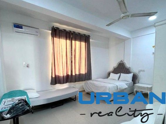 A room with a bed, a table, and a sofa in a 2-room apartment.