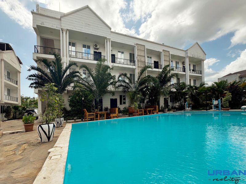 A building by the pool and palm trees in the Mbweni area of Zanzibar.