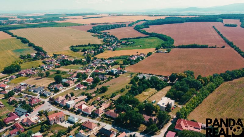 Aerial view of plots - housing in Čermany surrounded by vast fields and greenery.