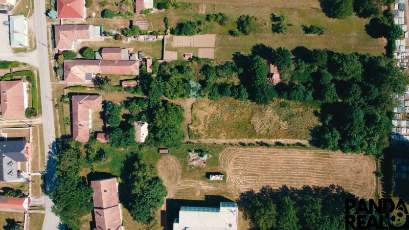 Aerial view of plots - housing in Čermany, surrounded by greenery and road infrastructure.