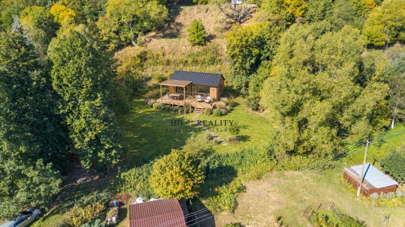 A wooden house in the forest among recreational plots in Štiavnické Bane.