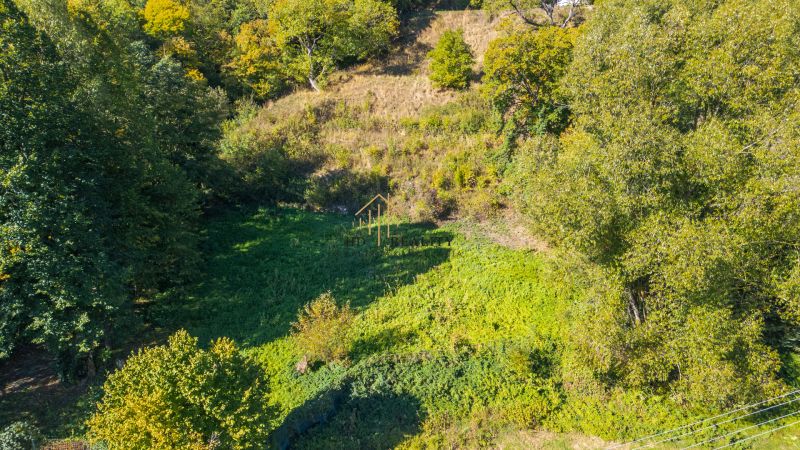 Recreational plots in Štiavnické Bane surrounded by dense vegetation and trees.