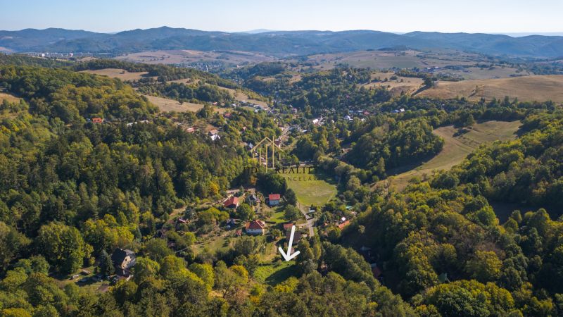 Aerial view of Recreational plots in Štiavnické Bane surrounded by green forests and hills.