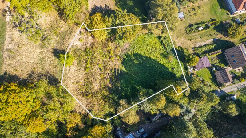 Aerial view of recreational plots in Štiavnické Bane surrounded by greenery and neighboring gardens.