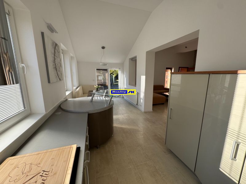 A space in a family house with a bright kitchen and dining area, and a wooden decor floor.