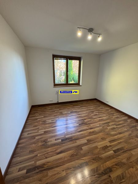 A room in a family house with a wooden decor floor and simple lighting.