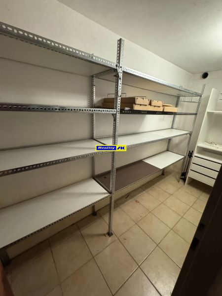 Storage space in a family house with metal shelves and tiled flooring.