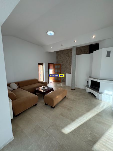 Living room in a family house with a fireplace and a spacious sofa set.