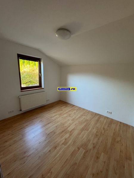 A room in a family house with a wooden decor floor and a radiator under the window.