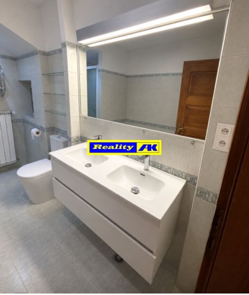 A bathroom with a double sink and a large mirror in a family house.