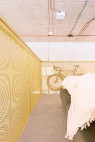 Attic space in a 2-room apartment with a bicycle and a sofa by the railing.