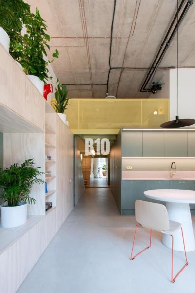 Interior of a 2-room apartment with plants, concrete ceiling, and built-in wardrobes.