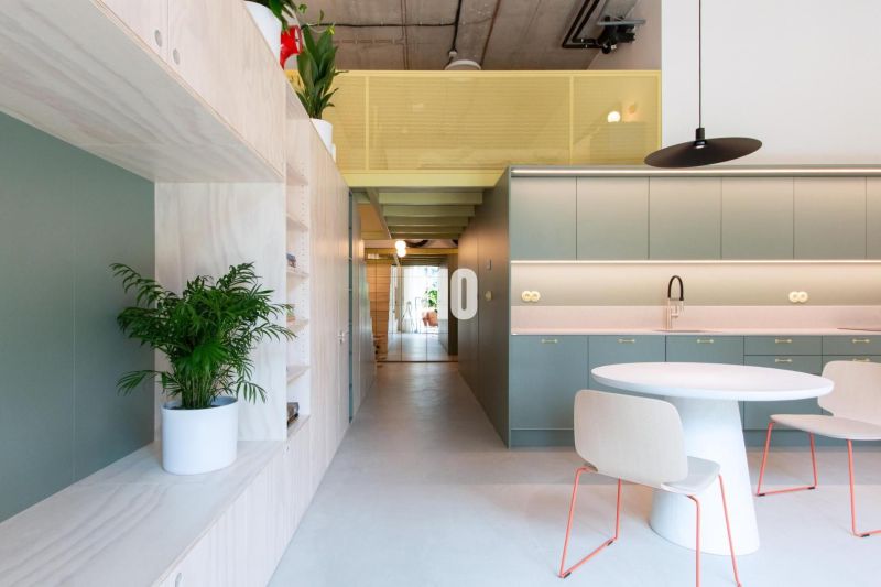 2-room apartment with a kitchen, green cabinets, a table, and a potted plant.