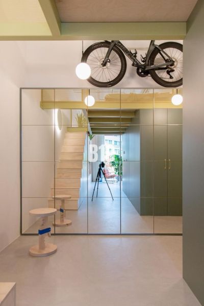 A mirrored wall and stairs leading to the floor in a 2-room apartment.