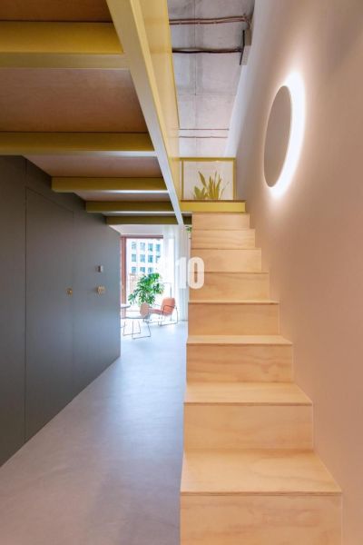 The staircase leads to the upper floor of a two-room apartment with a bright interior.