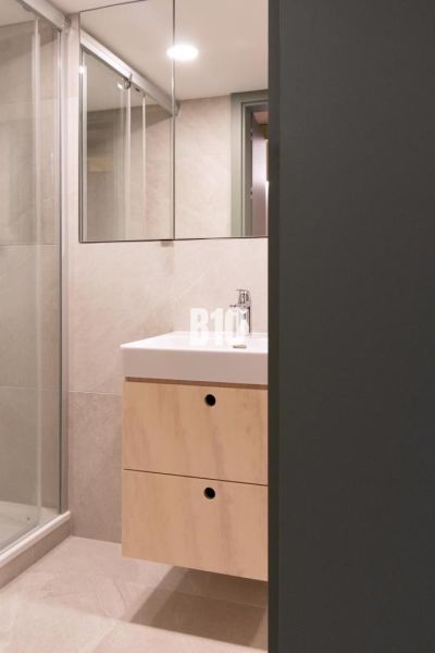 Bathroom with a sink and a shower in a 2-room apartment.