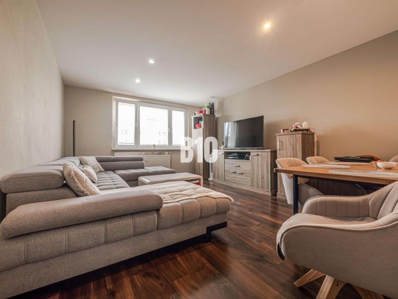 Living room in a 3-room apartment with a comfortable sofa and a wooden decor floor.