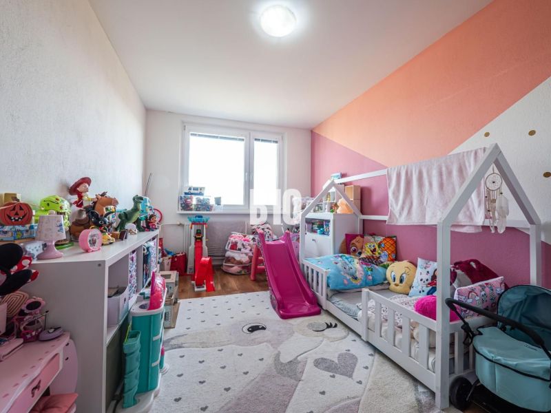 Children's room in a 3-room apartment with toys and a bed, floor with wooden decor.