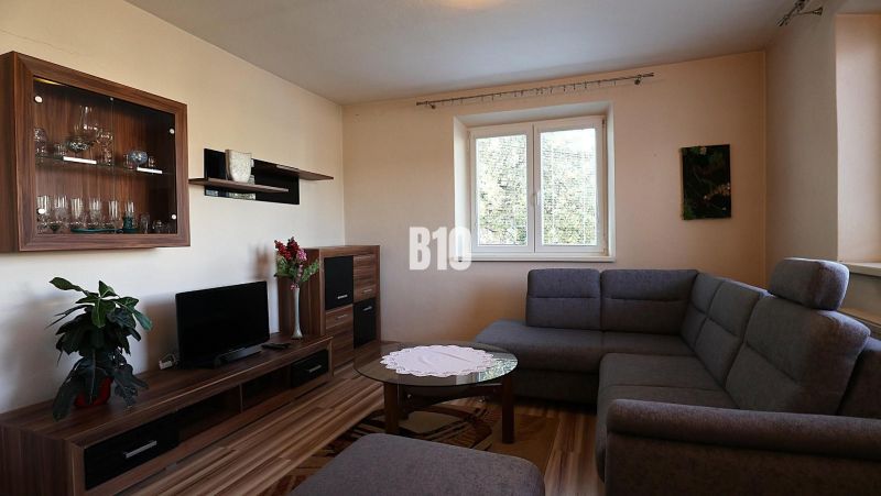 A living room in a family house with a comfortable sofa and a wooden decor floor.
