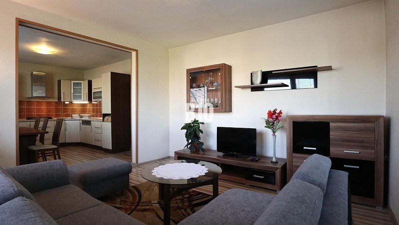 Living room in a family house with a view of the kitchen and a floor with a wooden decor.