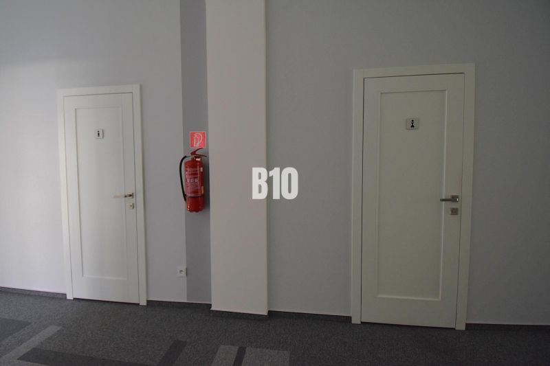 Doors in offices with a fire extinguisher on the wall.