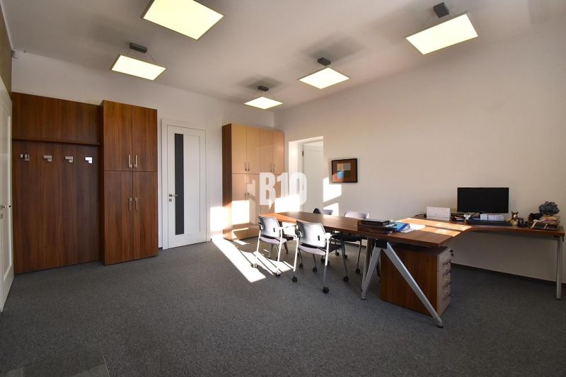 Offices with desks, chairs, and built-in wardrobes, illuminated by light fixtures.