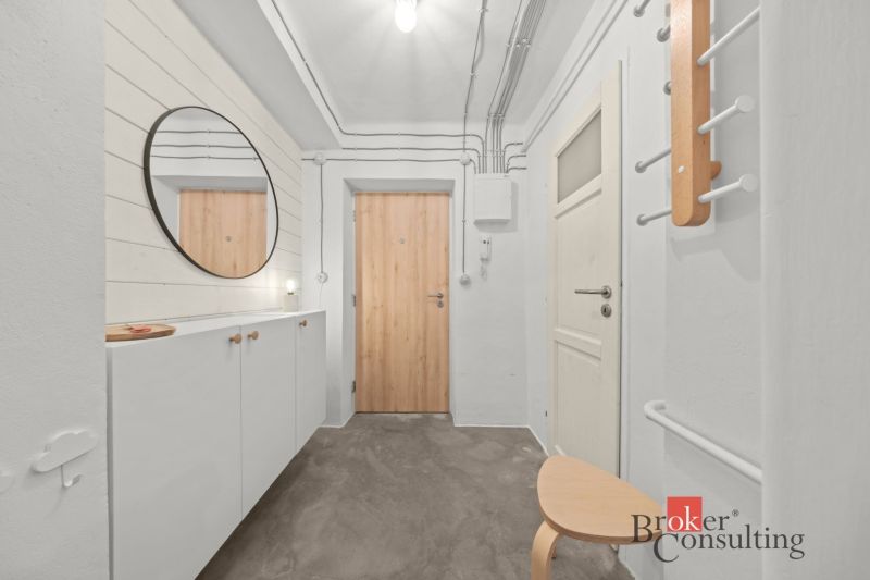 Entrance hallway with a white wardrobe and a mirror in a 2-room apartment.
