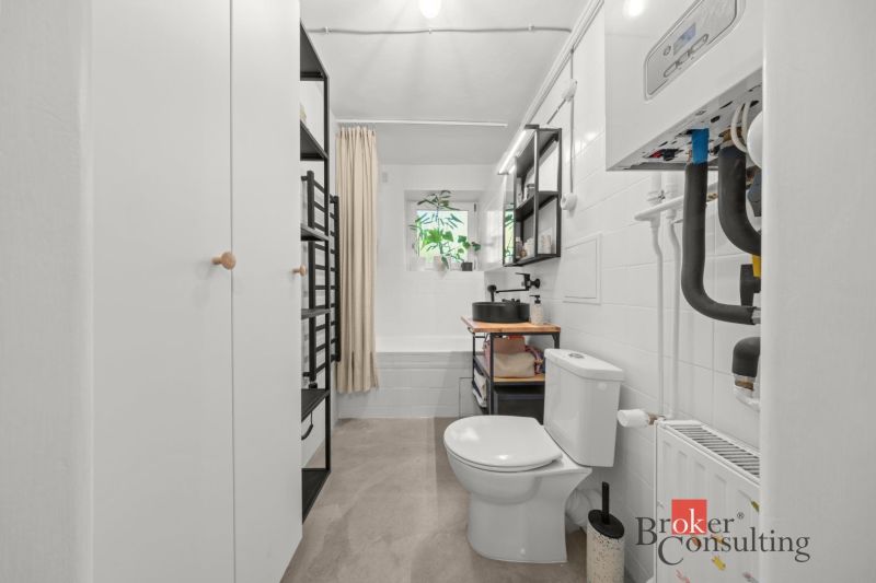 Bathroom with a bathtub, sink, and toilet in a 2-room apartment with modern amenities.